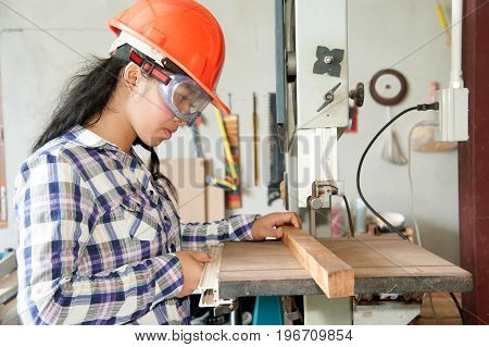 Asian pretty female carpenter using Electric Sander for wood.