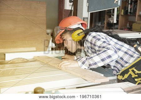 Asian pretty female carpenter Using Electric Sander for wood.