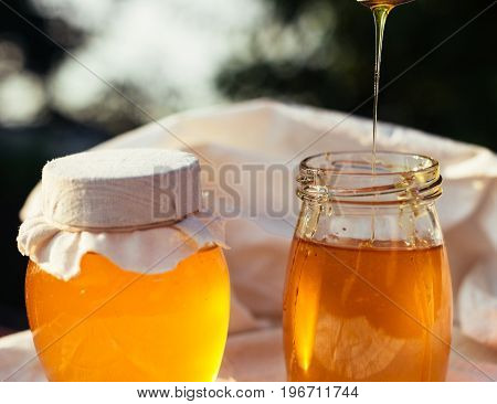 Two cans of natural honey. Honey on the fabric.