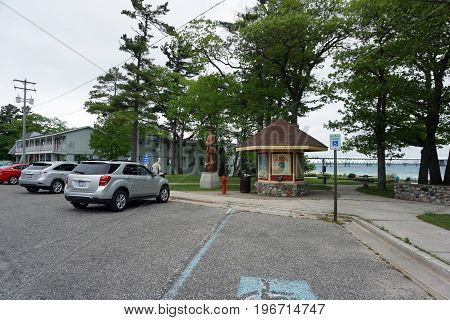 MACKINAW CITY, MICHIGAN / UNITED STATES - JUNE 18, 2017:  Visitors may sit in Alexander Henry Park, and enjoy the view of the Mackinac Bridge, which spans the Straits of Mackinac, to connect Michigan's Lower and Upper Peninsulas.