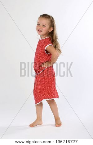 Cute little girl bare feet with red dress smiling