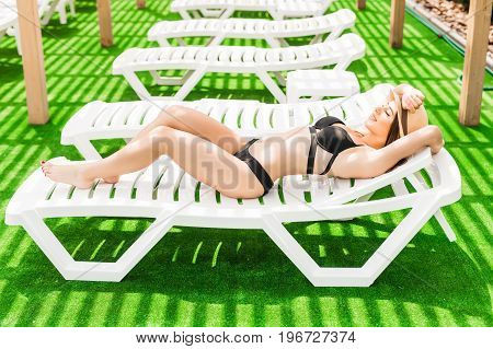 Woman Relaxing In Chaise Lounge At The Poolside. Summer Relax