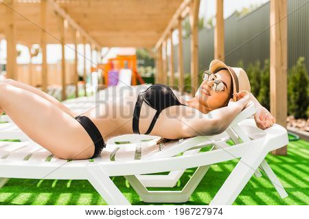 Woman Relaxing In Chaise Lounge At The Poolside. Summer Relax