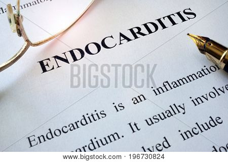 Paper with word endocarditis, pen and glasses.