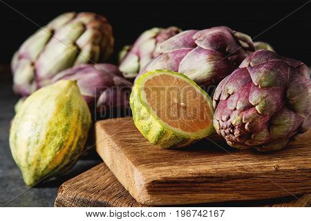 Baby Ripping Organic Artichokes With Lemon. Food For A Vegan And