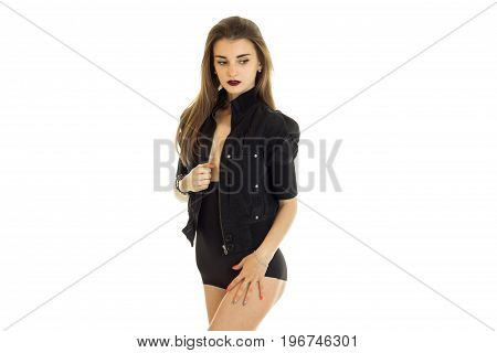 slender young lady in black body stands in the Studio in front of a camera isolated on white background