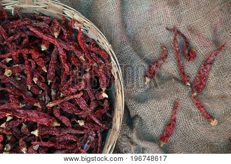 Pile of dried red chili peppers background, top view.