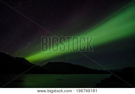 Northern lights at night over a lake in Igaliko Greenland