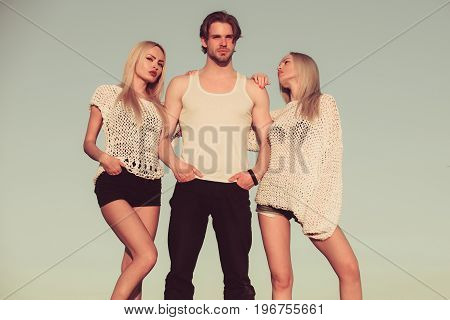 Love and romance. Blondes and guy with athletic chest. Beauty and fashion. Man with muscular body with twins. Girl and women with boyfriend outdoor.