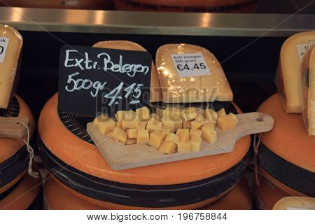 Traditional Dutch cheeses on display in a store (text on labels: price and product information in Dutch)