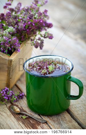 Enameled Mug Of Thyme Healing Herbs And Wooden Box Full Of Thymus Serpyllum For Healthy Herbal Tea.