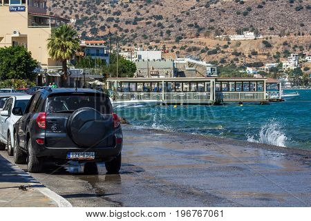 Elounda Crete Greece 22 September 2013: Cars are parked on a narrow path along the water's edge of the Mirabello Bay.