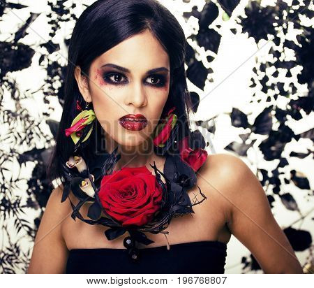 pretty brunette woman with rose jewelry, black and red, bright make up kike a vampire closeup red lips, halloween concept
