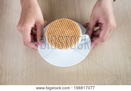 close up stroopwaffle on hot coffee cup serve on wood table and copy space