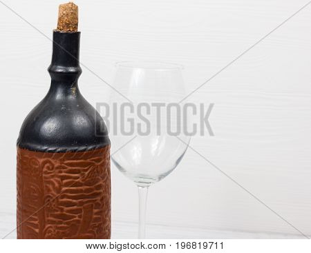 Black bottle of wine and wneglass on the background of the canvas
