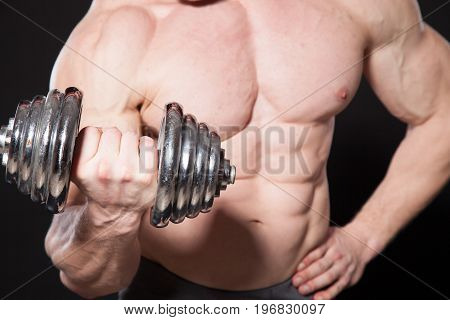 Sport the athlete bodybuilder shakes their muscles dumbbells