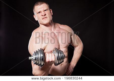 Sport the athlete bodybuilder shakes their muscles dumbbells