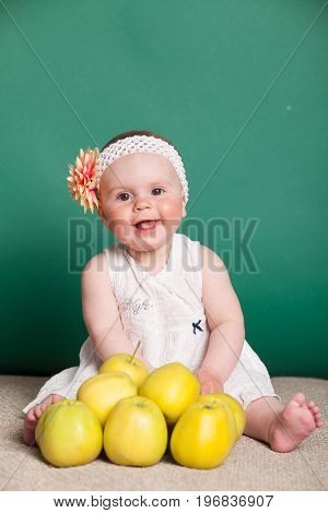 baby girl in a dress with Green apples 1