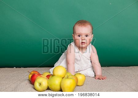 baby girl in a dress with Green apples 1