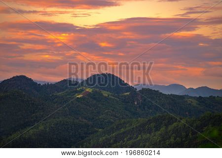 Beautiful dramatic sky sunset in the mountains with orange clouds. In Pang Ma Pha Meahongson Thailand.
