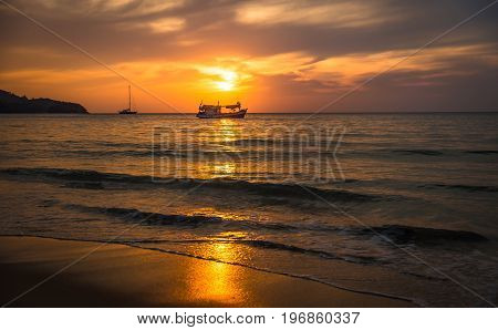 Beautiful sunset on the beach with fishing boat. Phuket Thailand.