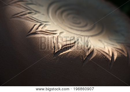 On a subject from ceramics the sun symbol is represented. At non-uniform illumination it is is better visible.