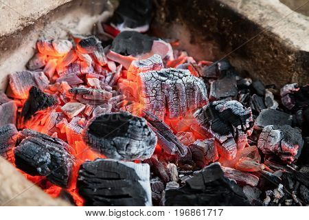 Burning hot coals lie in the fire and smolder