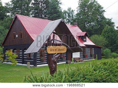 Ora Et Labora - Work And Pray -  Wooden  Poster Infront Of Beautiful Renovated Timer Cottage House