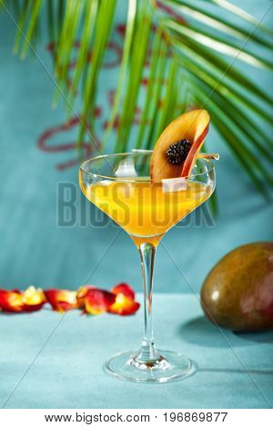 Summer  Cocktail -  Pornstar Martini. Drink with Passion fruit, Vodka, Liquor, Vanilla Syrup, Champagne and Lime Juice. Tropical Leaf on Background