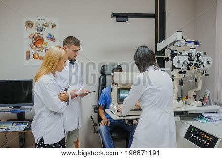 Eye Doctor/optometrist/ophthalmologist Examining A Young Patient And Explain To The Students