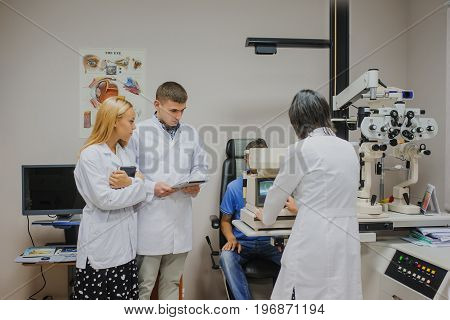 Eye Doctor/optometrist/ophthalmologist Examining A Young Patient And Explain To The Students