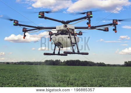 Agriculture drone fly to sprayed fertilizer on the green fields. drone flying with blue sky.