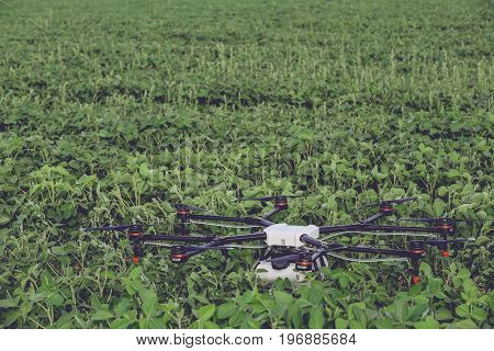 Professional big drone has landed and stands on a green field. Agriculture industry concept drone