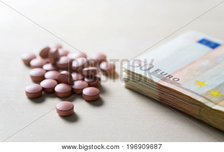 Medical business or prices concept. Making money in pharmaceutical industry or high medical expenses. Also drug dealing, dealer or trade. Pills, medicine, tablets and 50 euro bills and money on table.