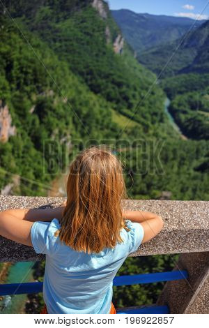 rear view of lonely girl looking on canyon on Djurdjevica Tara Bridge, Montenegro. Durmitor reserve.