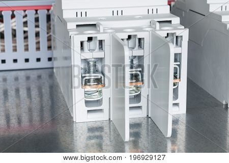 On a circuit Board fixed power circuit breaker with interphase partitions to protect. Circuit breaker with clips. In the background the cable channel laid with electric wires.