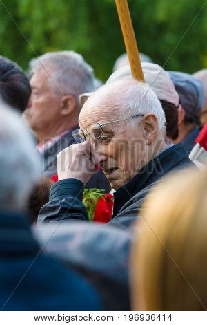 BERLIN - MAY 08 2015: Victory in Europe Day. Treptower Park. An elderly man a member of the commemorative ceremony wipes his away a tear.