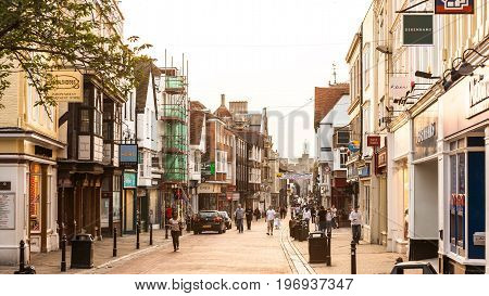 Canterbury Kent United Kingdom - June 16 2006: The High Street in Canterbury. Tourists visiting the historical city centre in the summer at sunset.