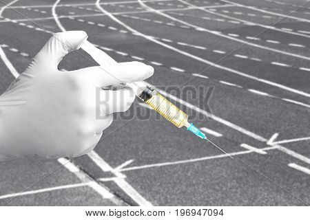 Scientist's hand in glove with syringe and running track on background, closeup. Sport and doping concept