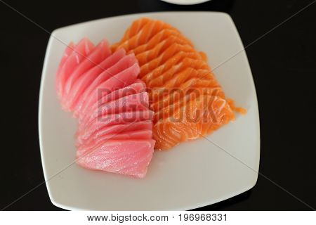 salmon and maguro sashimi on white dish.