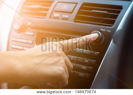 Passenger finger pushing button of car audio stereo player. Safety driver