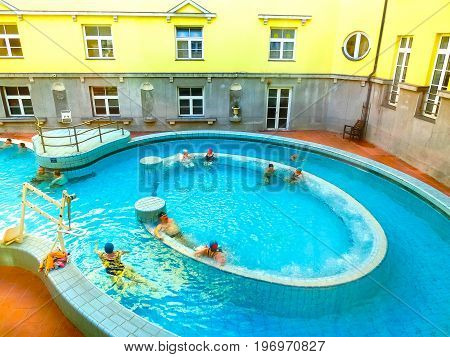 Budapest, Hungary - January 07, 2016: Tourists enjoy at the Lukacs Bath, at historic outdoor thermal bath heated naturally by hot springs, in Budapest, Hungary.
