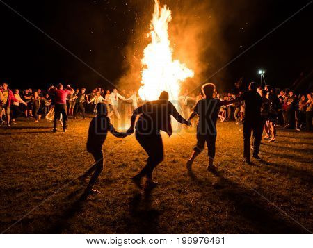 VOROCHEVO UKRAINE - JULY 16 2017: Lemko Vatra festival in Vorochevo Ukraine. People resting near big bonfire outdoor at night