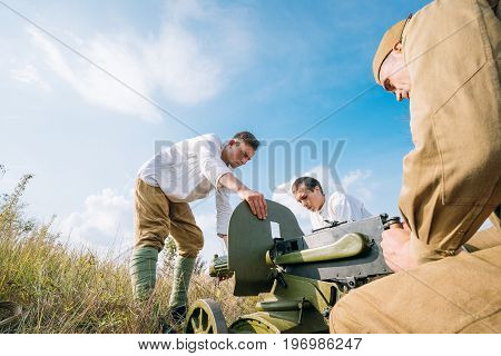 Dyatlovichi, Belarus - October 1, 2016: Reenactors Dressed As Russian Soviet Red Army Soldiers Of World War II Preparing Maxim's Machine Gun Weapon For Fight In Autumn Forest At Historical Reenactment