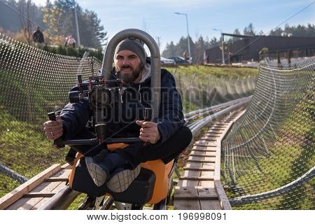 young videographer with gimball video slr at work on alpine coaster