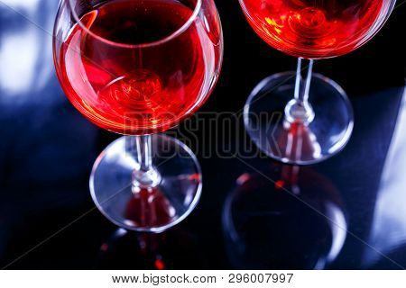 Two Glasses Of Red Wine In Bar, Night Club On Black Background With Reflection.