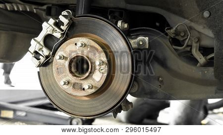 Car Parts And Disk Brake Concept - Closeup Car Disk Brake Maintenance Service In Car Garage And Copy
