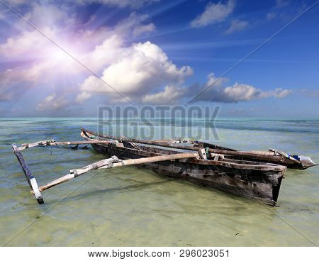 Wooden old fishing boat in turquoise ocean water in low tide time, Zanzibar