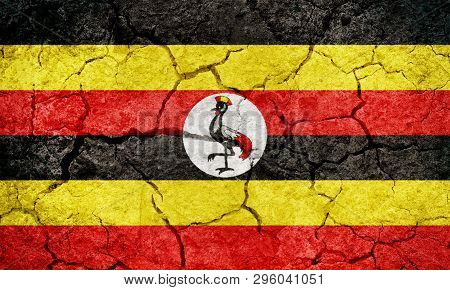 Republic Of Uganda Flag On Dry Earth Ground Texture Background