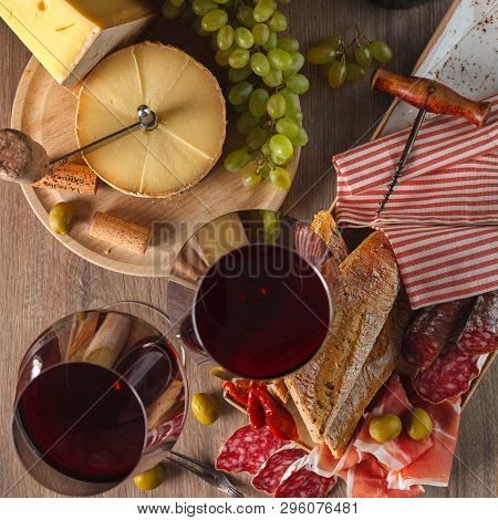 Red Wine In Glasses, Cheese, Baguette, Sun-dried Tomatoes And Olives. Composition.